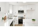 Modern kitchen with stainless steel appliances, white cabinets, and quartz countertops at 3643 S Mobile Way, Aurora, CO 80013