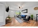 Bright living room with hardwood floors, black leather furniture, ceiling fan, and large window at 377 N 10Th Ave, Brighton, CO 80601