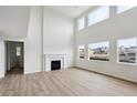 Soaring ceilings and a cozy fireplace in this light-filled living room with expansive windows at 5537 Riverbend Ave, Firestone, CO 80504