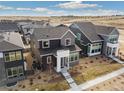 An aerial view of a two-story home with modern design, dark trim windows, and a well-manicured lawn at 6209 Stable View St, Castle Pines, CO 80108