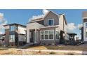 Charming two-story home featuring light grey siding, dark trim windows, and well-maintained landscaping at 6209 Stable View St, Castle Pines, CO 80108