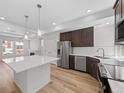 Modern kitchen featuring white quartz island, wood cabinets, stainless appliances, and wood floors at 1169 Highview Dr, Erie, CO 80516