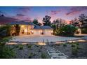 Elegant home featuring manicured landscaping, a circular driveway, and a grand facade enhanced by the evening light at 10914 Remmick Ridge Rd, Parker, CO 80134