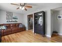 Cozy living room featuring hardwood floors, leather sofa, and ceiling fan at 3975 S Jason St, Englewood, CO 80110