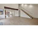 Bright open floor plan with stairs, laminate flooring, and view of kitchen at 12164 E Amherst Cir, Aurora, CO 80014