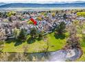 Aerial view of a townhome community with a picturesque pond and mountain views in the background at 10433 Red Mountain W, Littleton, CO 80127