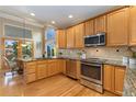 Bright kitchen with stainless steel appliances, wooden cabinets, and a breakfast nook with views of the backyard at 735 Orchard Ct, Louisville, CO 80027