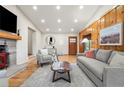 Bright living room with wood paneling, stone fireplace, and hardwood floors at 2020 Routt St, Lakewood, CO 80215