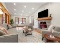 Spacious living room with a cozy stone fireplace, wood floors, and large windows at 2020 Routt St, Lakewood, CO 80215