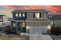 Inviting two-story home with a two-car garage and warm exterior lighting at 17947 E 95Th Ave, Commerce City, CO 80022