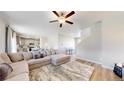 Spacious living room with hardwood floors, a plush sectional sofa, and seamless flow to the dining area at 17947 E 95Th Ave, Commerce City, CO 80022