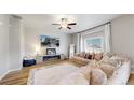 Cozy living room with a ceiling fan, fireplace, and comfortable furnishings at 17947 E 95Th Ave, Commerce City, CO 80022