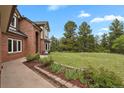 Beautifully landscaped yard with flower beds and mature trees surrounding the home at 1972 Gold Camp Way, Franktown, CO 80116