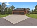 Spacious three-car garage with a large driveway leading to the brick home at 1972 Gold Camp Way, Franktown, CO 80116