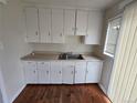 Functional kitchen with white cabinets, laminate countertops, and stainless steel sink basin at 1717 Oswego St, Aurora, CO 80010