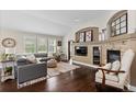 Bright living room with dark hardwood floors, fireplace, and built in TV and display case at 8216 S Tempe Ct, Aurora, CO 80016