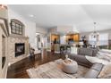 Spacious living room with a fireplace, hardwood floors, open layout, and leather seating at 8216 S Tempe Ct, Aurora, CO 80016
