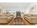 Living room with hardwood floors, fireplace, and view from large windows at 5272 Country Club Dr, Larkspur, CO 80118