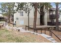Apartment building exterior with walking path, tidy landscaping, stairs leading to units, and mature trees at 9700 E Iliff Ave # G70, Denver, CO 80231