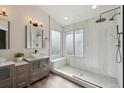 The bathroom showcases a luxurious walk-in shower with a glass enclosure, bench seat, and dual shower heads, along with a double vanity at 1534 Stanley Dr, Erie, CO 80516