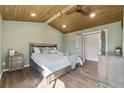 This primary bedroom is spacious with a wood plank ceiling, ceiling fan, and a large bed, creating a luxurious retreat at 1534 Stanley Dr, Erie, CO 80516