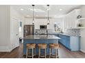 Bright, modern kitchen featuring a large island, stainless steel appliances, and stylish blue and white cabinetry at 1534 Stanley Dr, Erie, CO 80516
