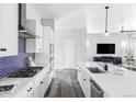Modern kitchen with stainless steel appliances, ample counter space, and stylish blue backsplash at 6037 N Netherland Ct, Aurora, CO 80019