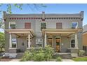 Charming townhome featuring a brick facade, covered front porches, and symmetrical design, exuding classic curb appeal at 2564 N Emerson St, Denver, CO 80205
