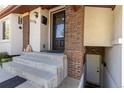 Inviting front porch featuring brick accents, a decorative door, and access to the basement at 3176 Depew St, Wheat Ridge, CO 80214