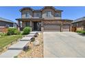 Inviting two-story home featuring a stone facade, three-car garage, and manicured landscaping at 76 N Ider St, Aurora, CO 80018