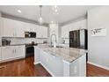 Modern kitchen featuring white cabinetry, stainless steel appliances, and a granite-topped island at 76 N Ider St, Aurora, CO 80018