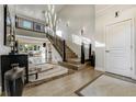 Grand foyer with high ceilings, hardwood floors, staircase, and modern chandelier lighting at 4181 S Ivy Ln, Cherry Hills Village, CO 80111