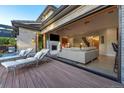 The outdoor deck with luxurious lounge seating transitions to the living room through sliding doors at 4181 S Ivy Ln, Cherry Hills Village, CO 80111