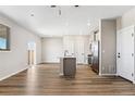 Open-concept living room and kitchen featuring hardwood floors and natural light at 9454 Yampa St, Commerce City, CO 80022