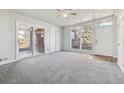Spacious living room featuring sliding glass doors, bright natural light, and neutral carpeting at 8280 E 104Th Way, Henderson, CO 80640