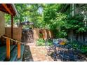 Charming backyard patio features a brick ground cover, metal table with seating, and lush green foliage at 807 9Th St, Golden, CO 80401