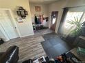 View of living area with wood-look floors, seating, storage, and a door with a window view at 1489 Arapahoe St, Strasburg, CO 80136
