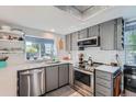 Charming kitchen features stainless appliances, gray cabinets, white tile backsplash, and modern countertop at 6311 Xavier St, Arvada, CO 80003