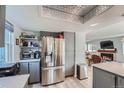 Bright kitchen features gray cabinets, stainless steel refrigerator, and open shelving at 6311 Xavier St, Arvada, CO 80003