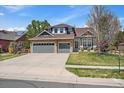 Charming two-story home with stone accents, a three-car garage, and a well-manicured front lawn at 2861 Madison Ln, Broomfield, CO 80023