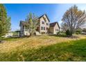 Beautifully landscaped front yard features a well maintained lawn and mature trees at 3225 Rinn Valley Dr, Longmont, CO 80504