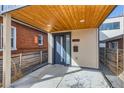 Inviting front porch with a wood ceiling, modern door, and stylish house number at 3439 N High St, Denver, CO 80205