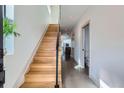 Bright hallway with wooden stairs, white walls, and a view into the open kitchen and bathroom at 3439 N High St, Denver, CO 80205