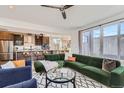 Open-concept living room with modern furnishings, a large green sofa, and natural light at 3439 N High St, Denver, CO 80205