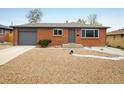 Charming brick home with a well-maintained yard, gray trim, and an attached garage at 740 Lotus Way, Broomfield, CO 80020