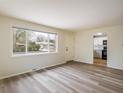Bright, open living room with hardwood floors and a large window overlooking the front yard at 740 Lotus Way, Broomfield, CO 80020