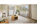 Bright living room showcasing a white chair, round table, and a large window allowing lots of natural light at 740 Lotus Way, Broomfield, CO 80020