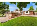 Charming two-story brick home with a well-maintained lawn, a front patio area, and a two-car garage at 6798 Depew St, Arvada, CO 80003
