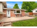 Inviting front porch of a brick home with seating, a well-maintained lawn, and a bright, welcoming entrance at 6798 Depew St, Arvada, CO 80003