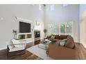 Bright living room featuring a fireplace, hardwood floors, and a vaulted ceiling with lots of natural light at 7838 W Layton Way, Littleton, CO 80123